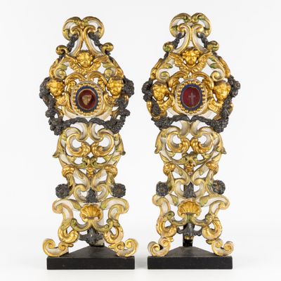 paire de bougeoirs en verre doré et rouge reposant sur des socles en marbre noir