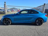 une BMW M2 Coupé bleue garée sur un parking