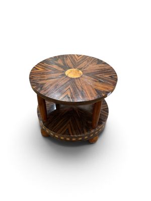 une table en bois avec un plateau circulaire posé sur un plan de travail blanc