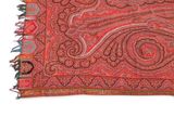 a close up of a red rug with a paisley design on it