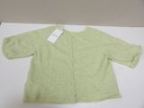the sweater is green and has a white tag on it