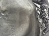 a close up of a black jacket with ruffles on it