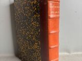 an old book sitting on top of a table next to a white wall