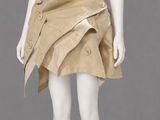 a mannequin wearing a tan skirt with buttons and a white top
