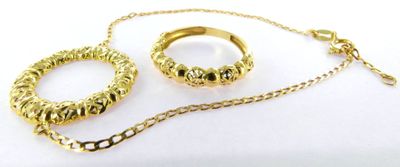 two gold rings and a chain on a white surface