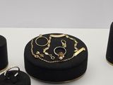 une boîte noire sur laquelle sont posés des bijoux en or