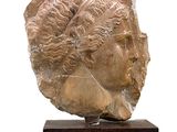 statue représentant la tête d'une femme, posée sur un socle en bois