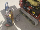 a small machine that is on the ground next to a truck