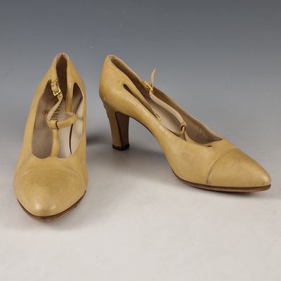 paire d'escarpins beiges pour femme, avec des boucles dorées sur le bout
