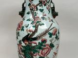 un vase avec un oiseau posé sur une table