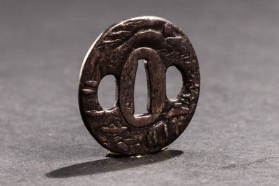 un petit objet métallique posé sur une table, sur lequel se projette une ombre