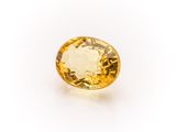 a yellow sapphire stone on a white background