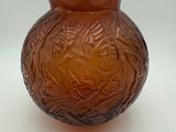 a brown glass vase with a design on it