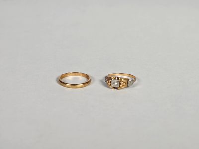 deux bagues en or ornées de diamants, posées sur une surface blanche