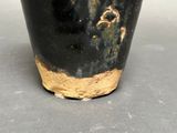 a black and gold vase sitting on a table