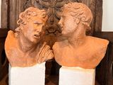 two busts of men sitting on a wooden chair