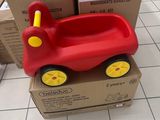 une petite voiture rouge posée sur une boîte en carton