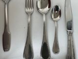 a lot of silver spoons and forks on the table