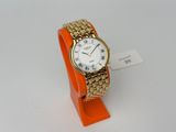 an image of a gold and white wrist watch on an orange stand