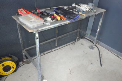 une table sur laquelle sont posés des outils, dans un coin de la pièce