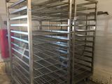 a large metal rack with several trays of food inside of it