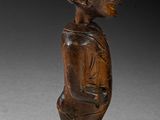an image of a wooden statue of a woman with a hat on her head