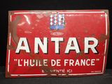 une vieille enseigne rouge et blanche sur laquelle est inscrit le mot « antar »