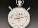 un chronomètre argenté avec une trotteuse rouge sur un fond noir