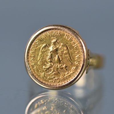 une image représentant une bague en or avec une pièce au milieu