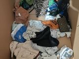 a cardboard box filled with clothes and shoes on the floor