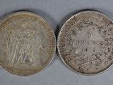 two silver coins, one of which is a woman and one of which is a man
