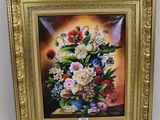 tableau représentant un bouquet de fleurs dans un cadre doré, accroché à un mur blanc