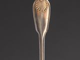 a silver spoon with a handle on a black surface