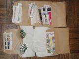 several envelopes are sitting on a wooden floor covered in papers