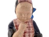 a small figurine of a woman sitting on the ground