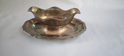 un service en argent ancien composé d'une assiette et d'une soucoupe posée dessus
