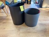 two black trash cans sitting on the floor next to each other