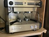a coffee machine sitting on top of a shelf next to a refrigerator