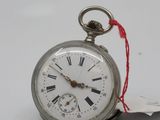 a silver pocket watch with roman numerals on it