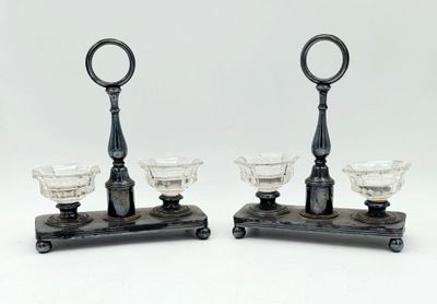 paire de bougeoirs anciens en verre posés sur un socle en fonte