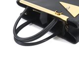 the black and gold handbag is sitting on a white surface