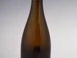 an old bottle of wine sitting on top of a white table