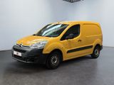La camionnette jaune est garée dans une grande pièce blanche.