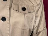 a close up of a mannequin mannequin wearing a tan jacket