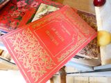 deux livres posés sur une table avec des pommes, et une pomme en arrière-plan