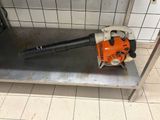 a blower sitting on a metal shelf in a bathroom