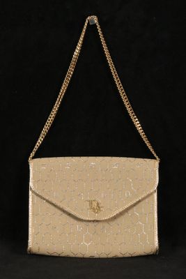 un sac à main beige muni d'une chaîne qui pend sur l'épaule