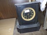 a black clock sitting on top of a wooden table