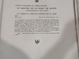 un livre ouvert posé sur une table, à côté d'une tasse