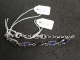 two bracelets with a tag attached to them sitting on a table